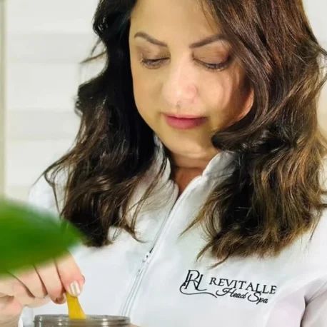 Marineuza Branco, de jaleco branco com o logo da Revitalle, preparando um produto para o tratamento
